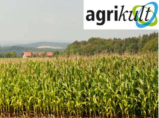 Das agrikult Logo vor einer Landschaft mit Maisfeld. 